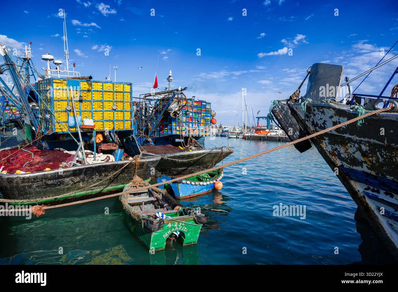 Farbenfrohe Fischerboote legten an einem lebhaften, geschäftigen Hafen unter einem klaren blauen Himmel an. Essaouira, Marokko Stockfoto