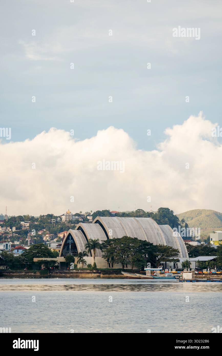 Malerischer Blick auf eine Küstenstadt mit einem einzigartigen architektonischen Gebäude und bewölktem Himmel. Ambon, Maluku, Indonesien Stockfoto