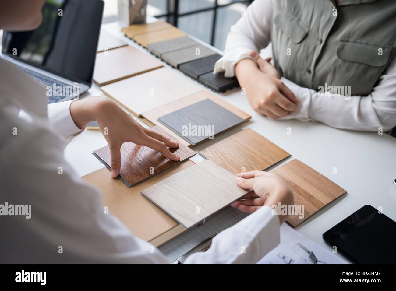 Innenarchitektin präsentiert umweltfreundliche Holzmaterialmuster für nachhaltige Wohnkultur Stockfoto
