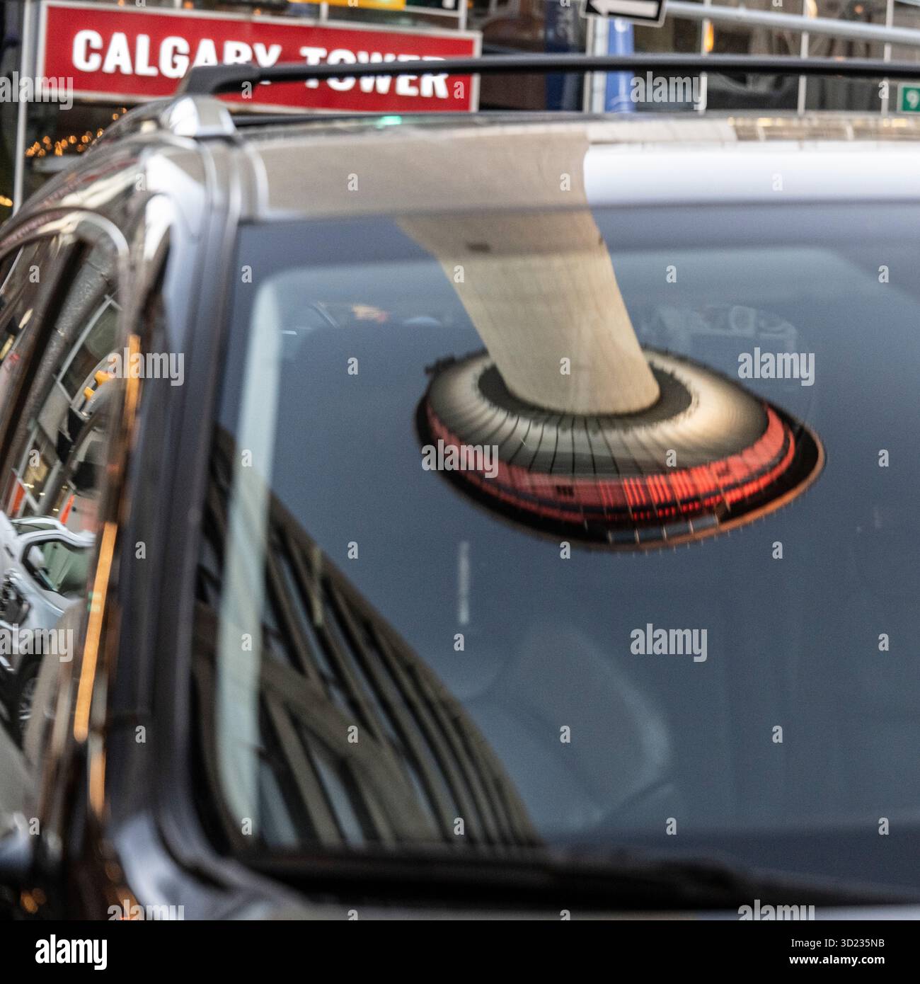 Reflexion des Calgary Tower an einem Autofenster mit umliegender städtischer Umgebung. Calgary, Alberta, Kanada Stockfoto