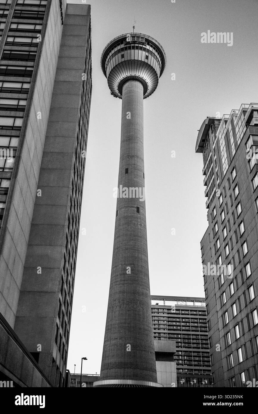 Schwarz-weiß Blick auf einen hohen Turm, umgeben von städtischen Gebäuden in einem Stadtbild. Calgary, Alberta, Kanada Stockfoto