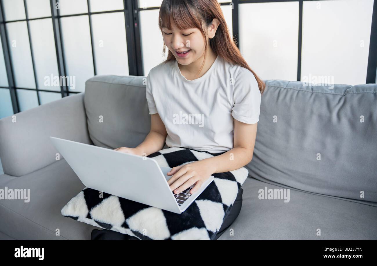 Asiatische Frau, die Entertainment-Video-Streaming per Laptop ansieht Stockfoto