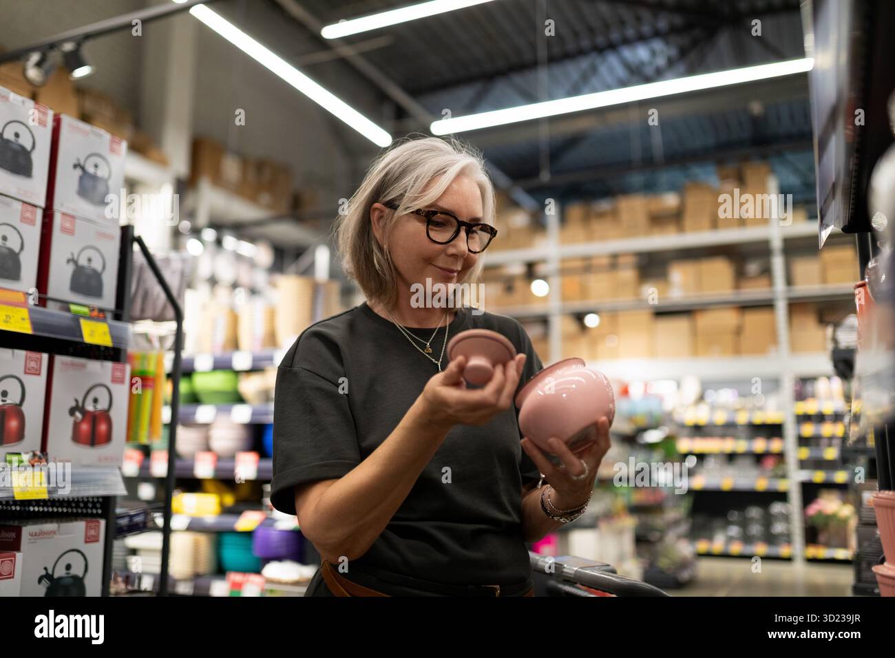 Stilvolle, reife Frau wählt in einem modernen Baumarkt Haushaltswaren aus und präsentiert zeitgenössische Lebensstile Stockfoto