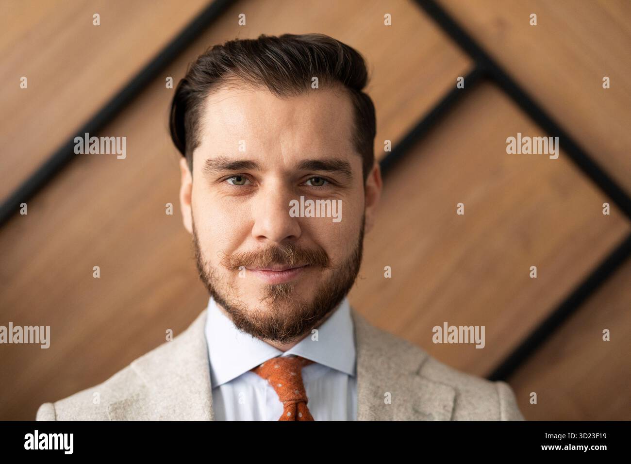 Lächelnder junger Geschäftsmann in klassischer schwarzer Hemdkrawatte, der isoliert im Büro posiert Stockfoto