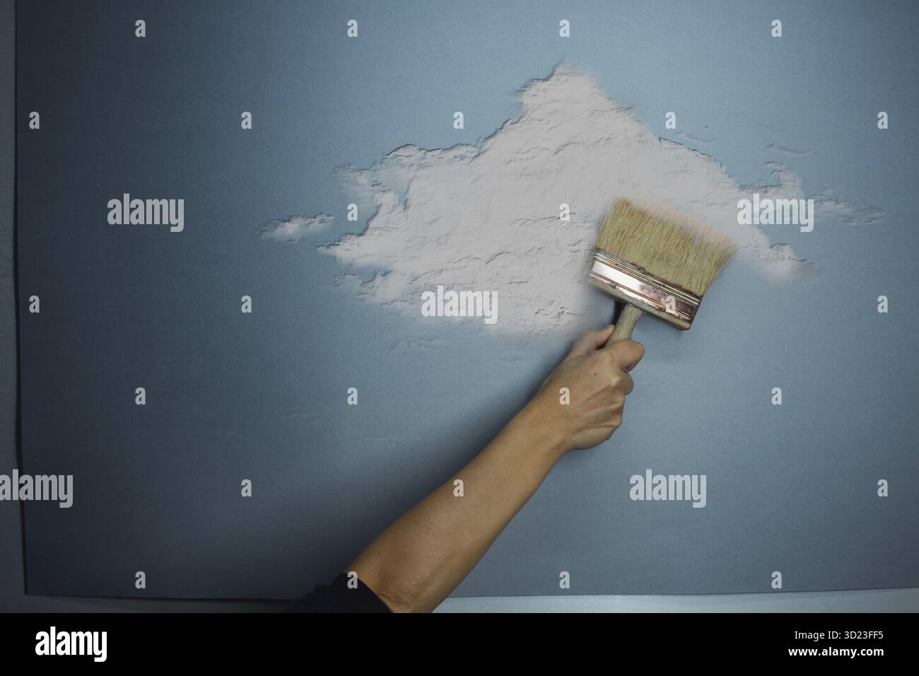 Hand einer Person, die eine Wolke auf eine himmelblaue Wand malt, Idee, Fantasie, Freiheit, Kunst Stockfoto