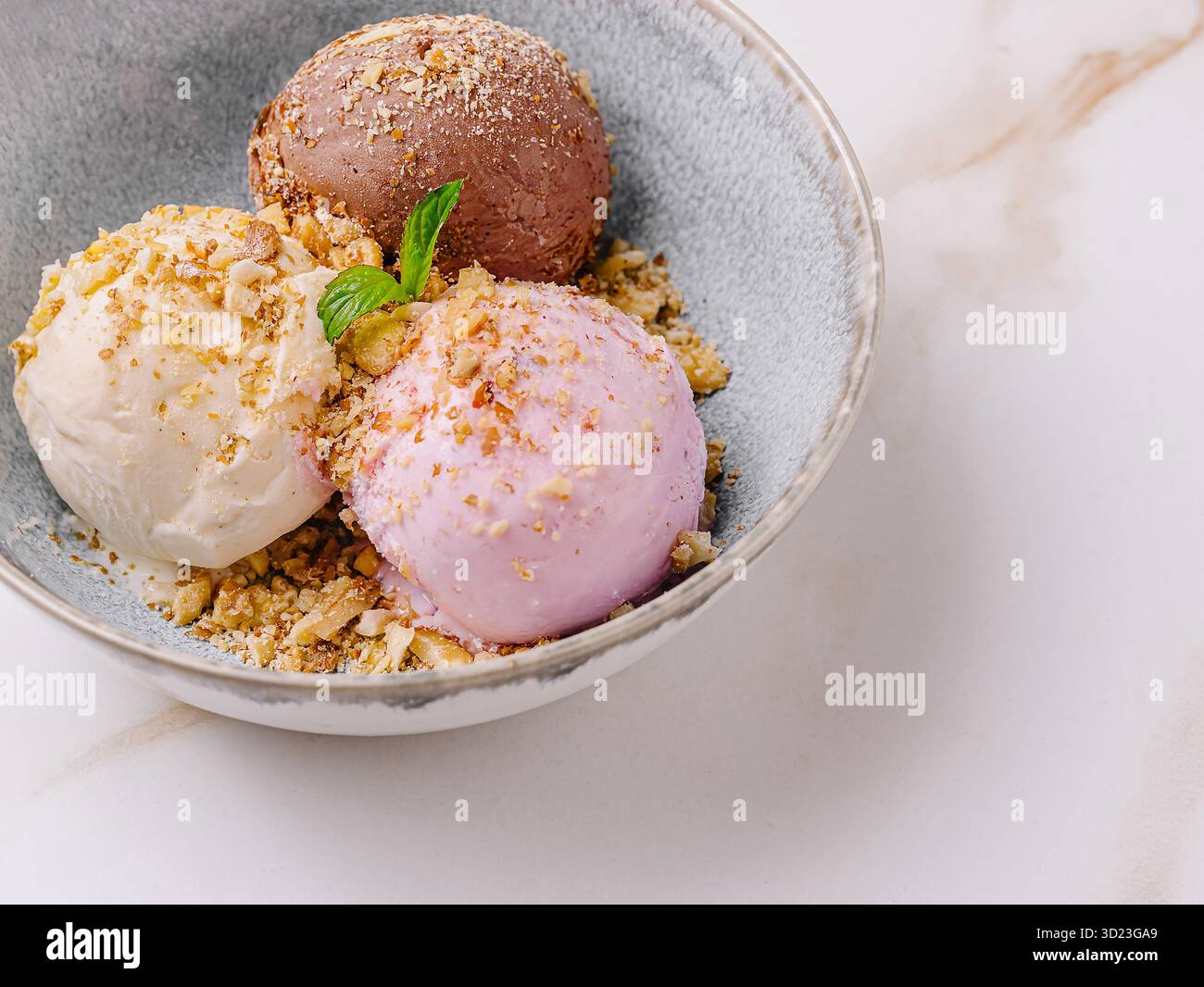 Verschiedene Eissorten in einer Schüssel mit Belag serviert Stockfoto