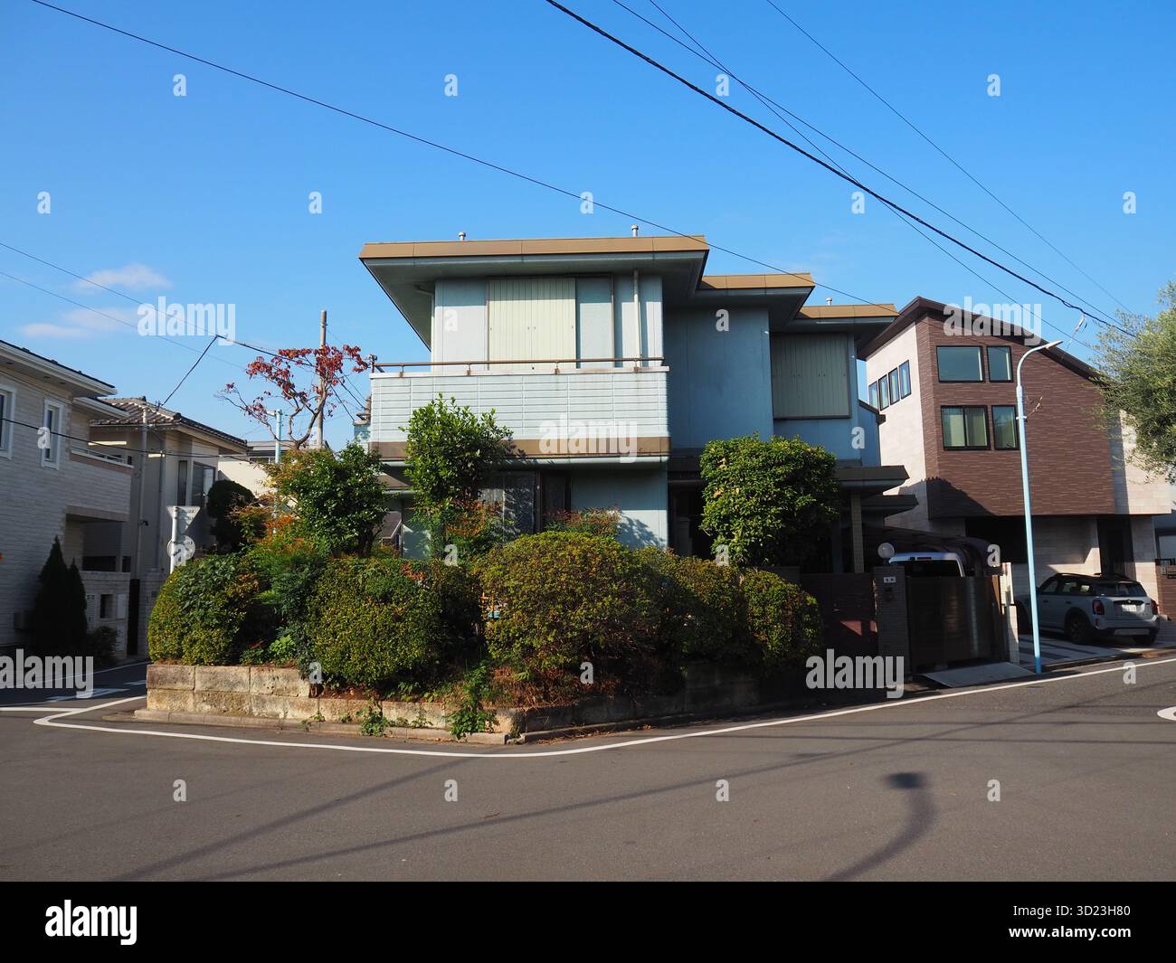 Modernes Eckhaus mit Garten in einer ruhigen Wohngegend von Tokio unter blauem Himmel Stockfoto