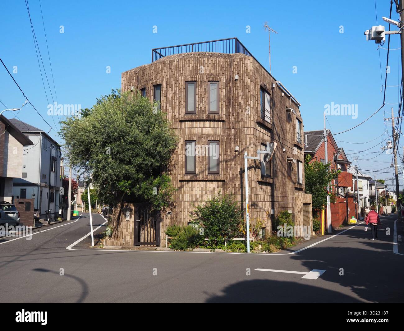 Dreistöckiges Eckhaus im Backsteinstil in einer schmalen Straße in einem Wohngebiet von Tokio Stockfoto