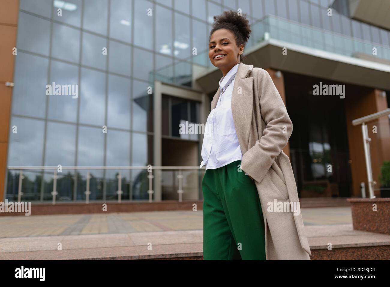 afroamerikanische Ökonomen über finanzielle Arbeit vor dem Hintergrund eines nicht modernen Bürogebäudes draußen, der auf das C blickt Stockfoto