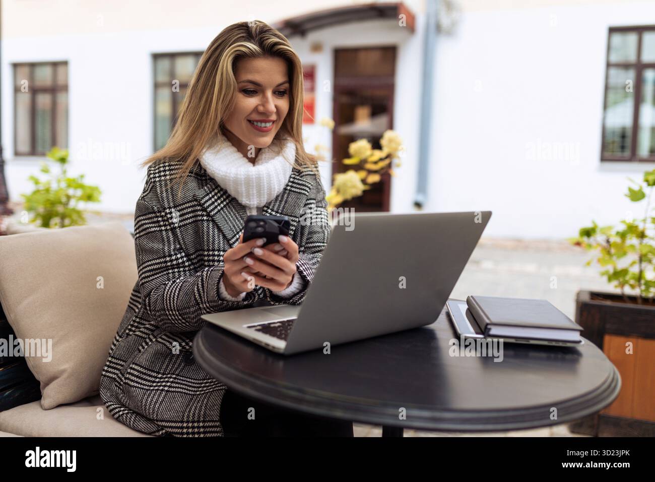 Frau, die online am Laptop im Stadtcafé arbeitet, Unternehmensrisiko-Versicherungskonzept Stockfoto