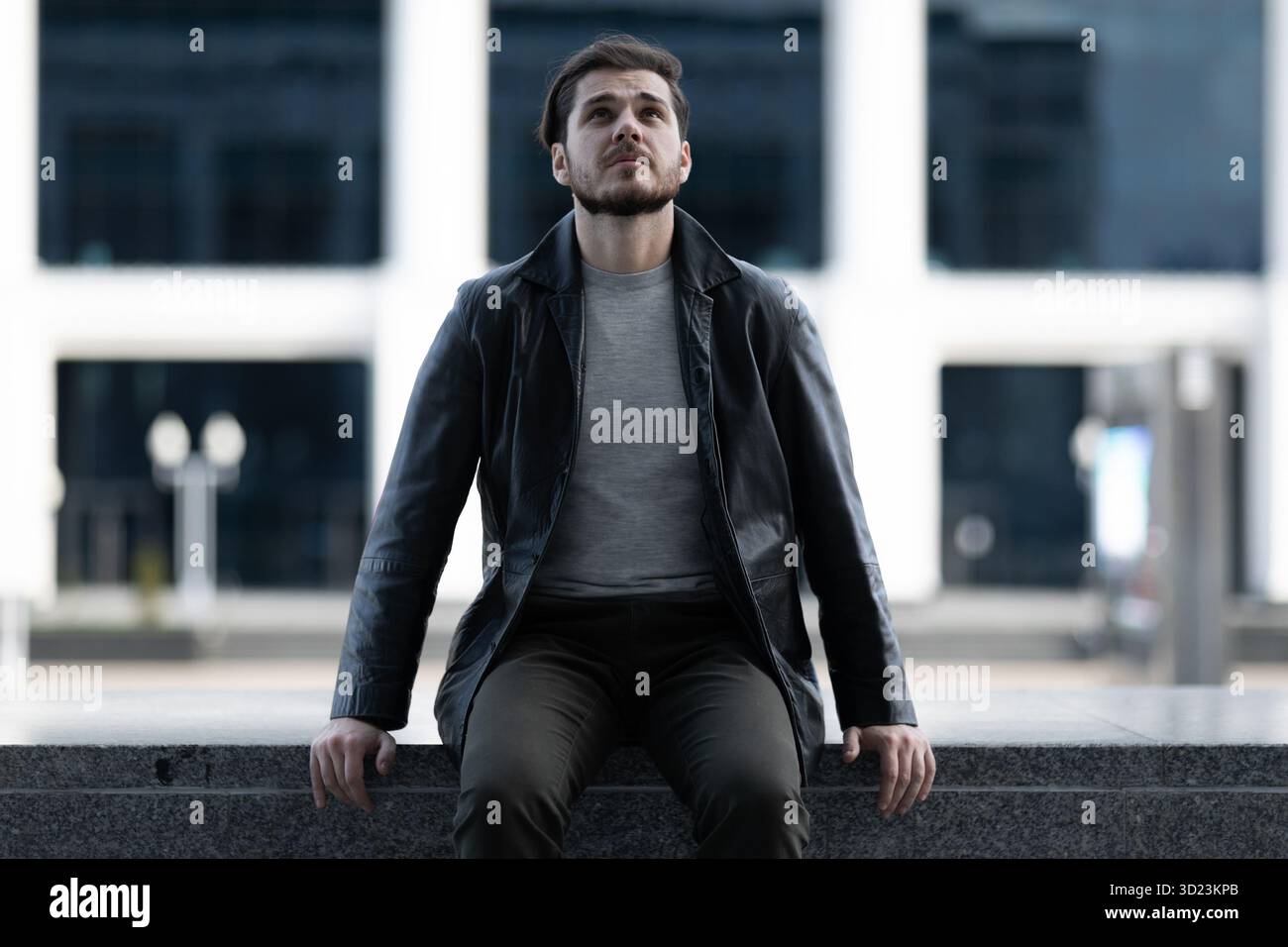 Emotional haben Sie einen Mann in einem depressiven Zustand auf einer Betonbrüstung in der Stadt verfilzt Stockfoto