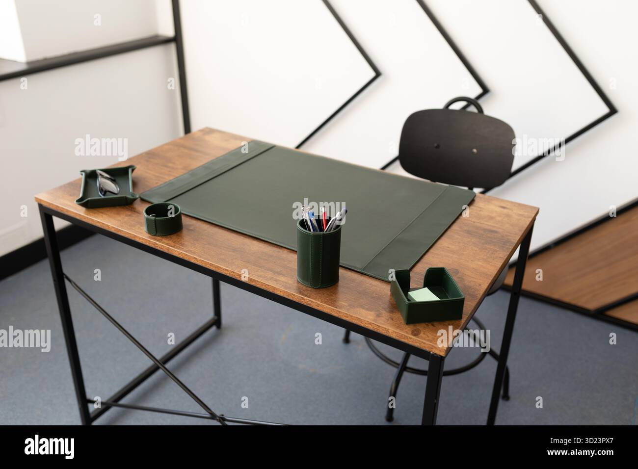 Sauberer, aufgeräumter Arbeitsplatz im Büro mit grünem Schreibblock und Büromaterial Stockfoto