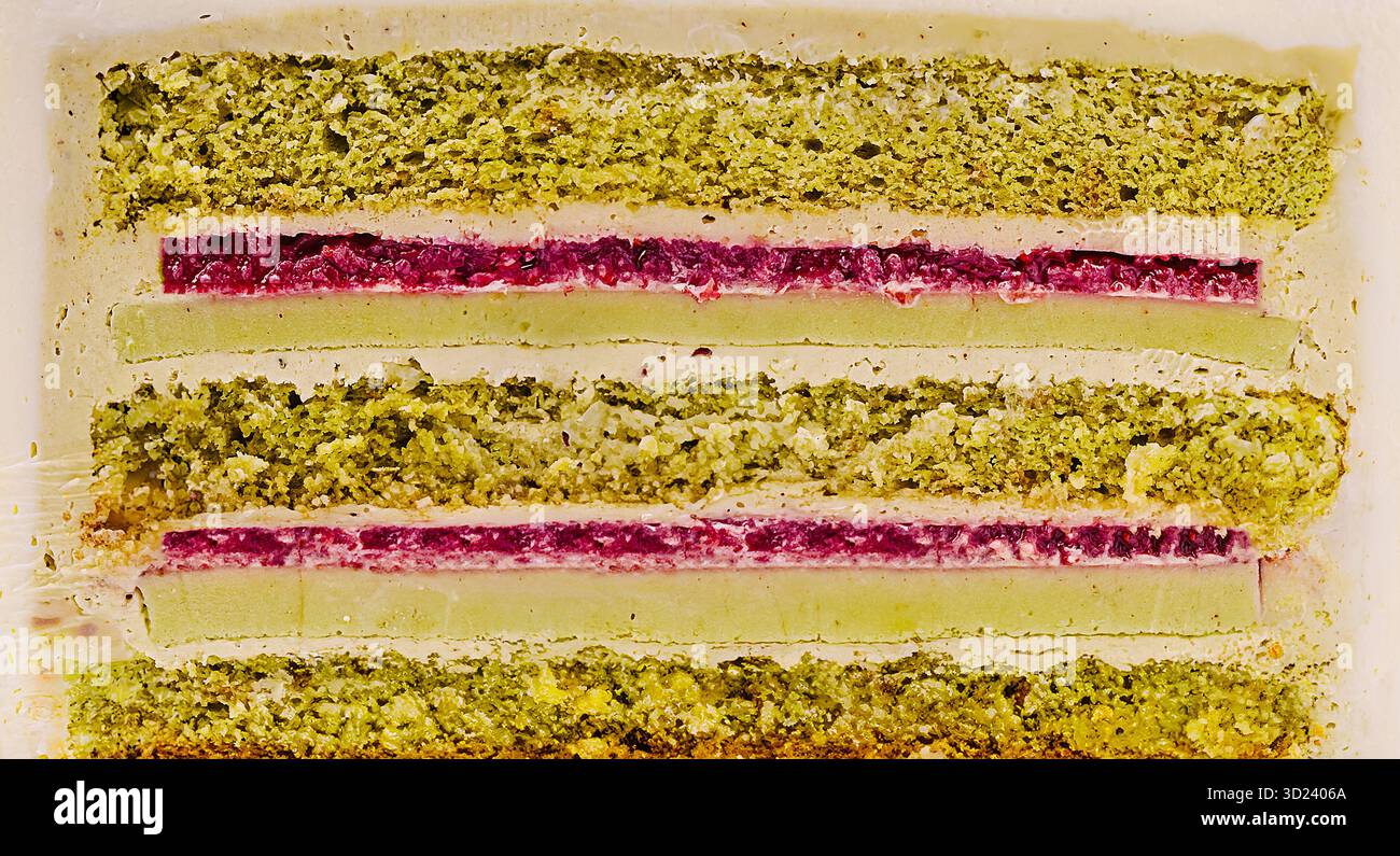 Farbenfrohe Dessertschichten mit grünen und roten Füllungen auf weißem Boden Stockfoto