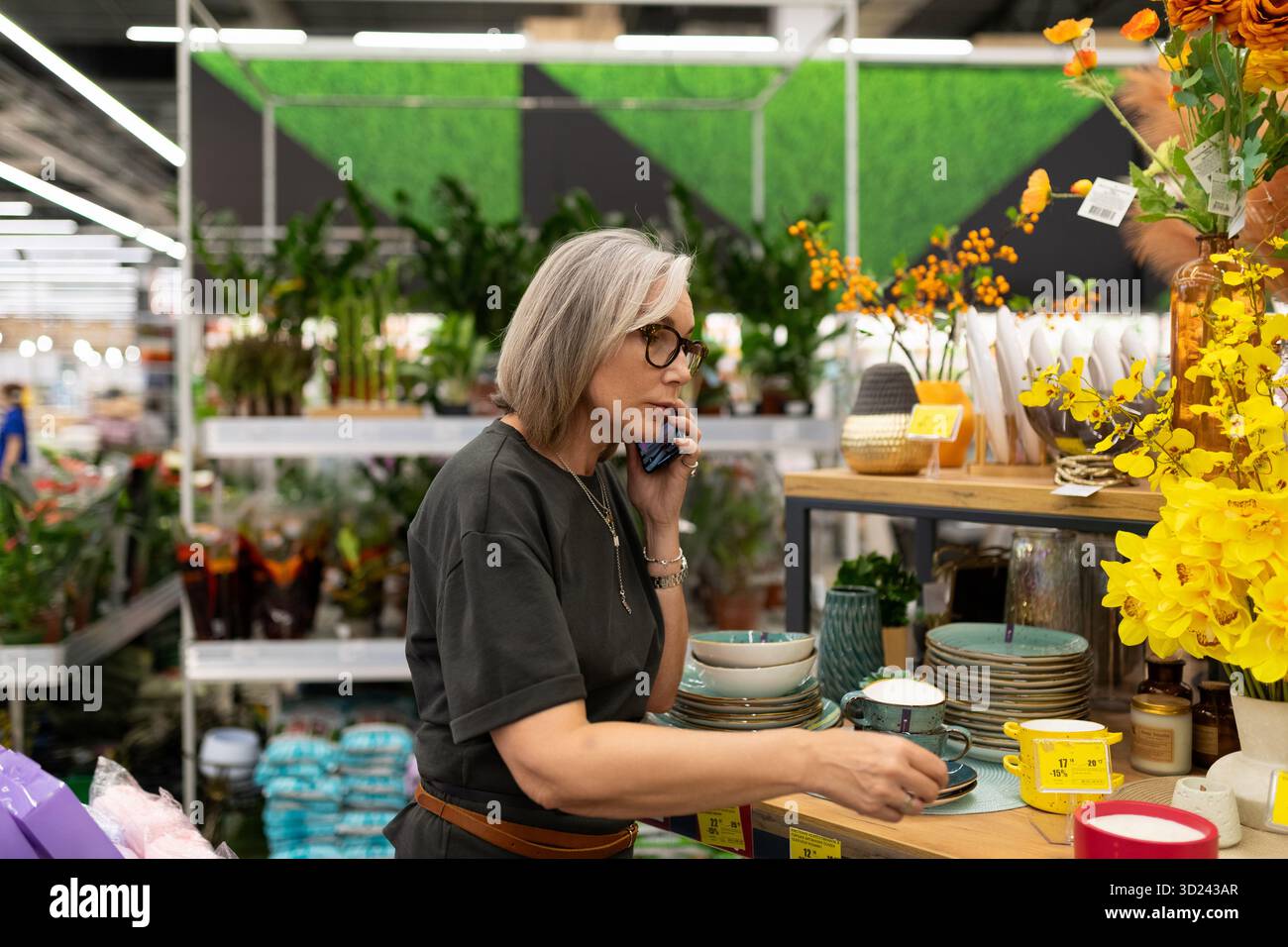 Reife Frau, die in einem großen Einzelhandelsgeschäft Haus- und Gartenprodukte kaufte Stockfoto