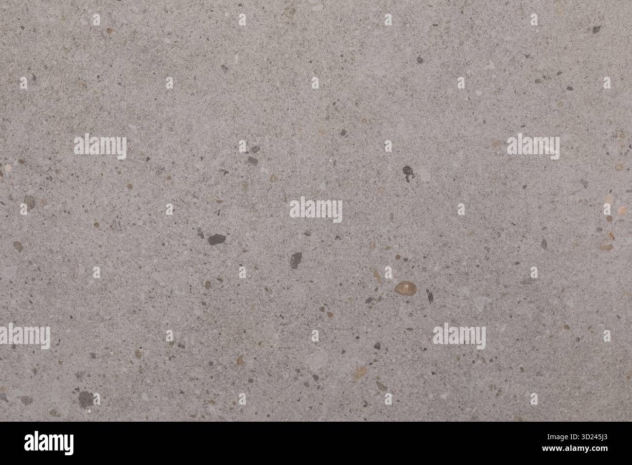 Hellgraue Betonoberfläche mit kleinen Steinen und Texturen, die natürliche Muster und Farbvariationen zeigen Stockfoto