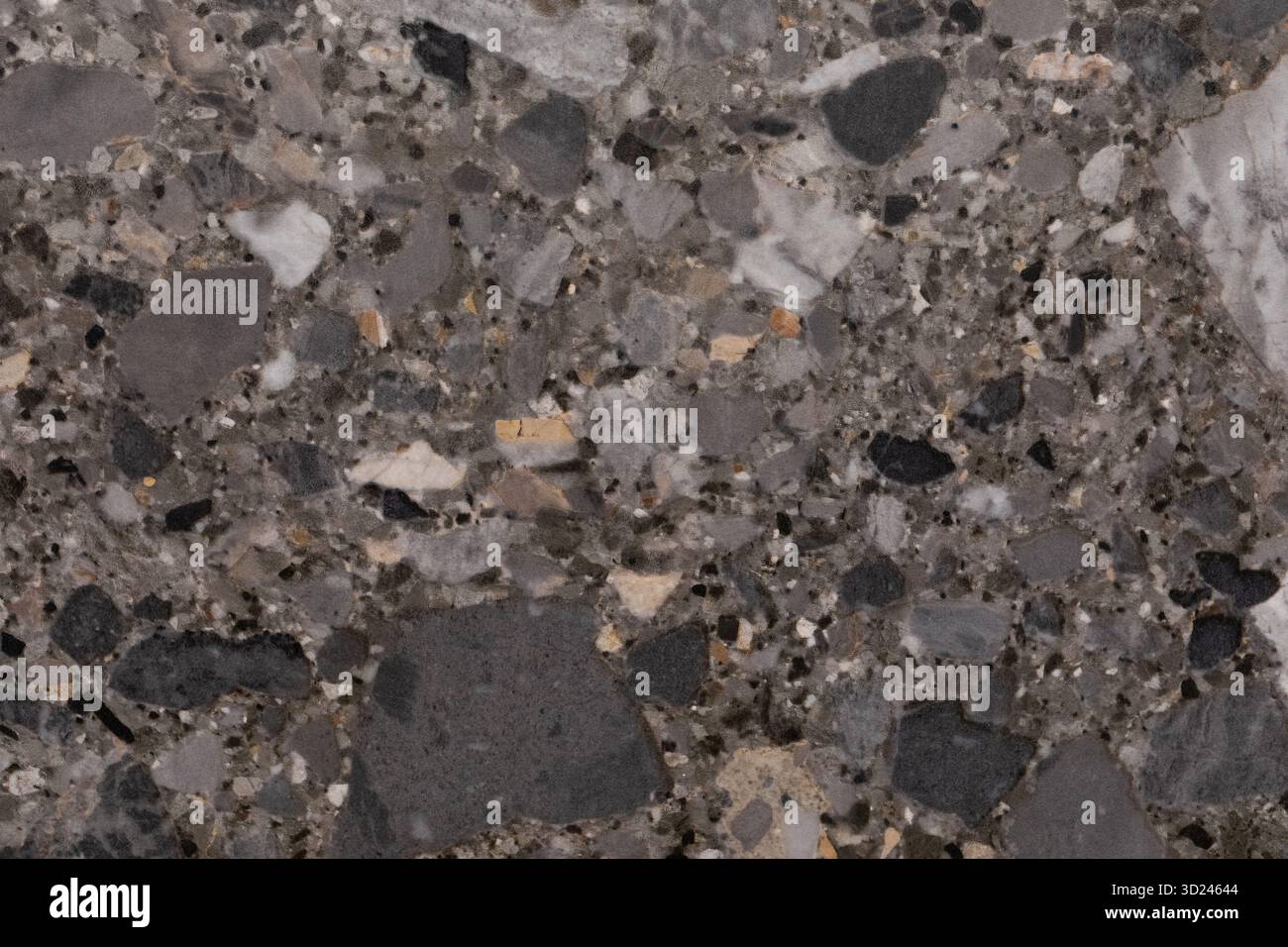 Der Terrazzo-Boden zeigt eine auffällige Auswahl an Grautönen zusammen mit bunten Steinschlägen. Dieses moderne Design verleiht jedem Innenraum Eleganz, Stockfoto