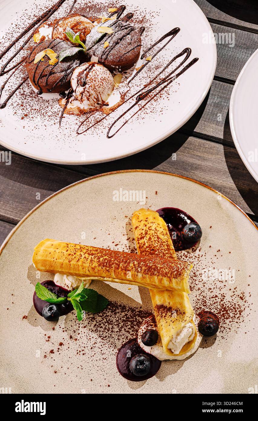 Desserts werden in einem trendigen Restaurant mit eleganter Präsentation am Abend serviert Stockfoto