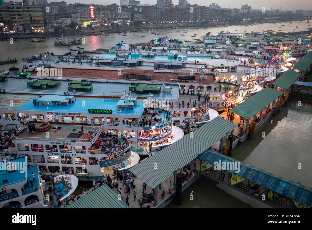 Aus der Vogelperspektive des belebten Flusshafens, wo Boote und Schiffe dicht neben den Docks sind, gefüllt mit Menschen in einer lebhaften Szene, Dhaka, Dhaka Div Stockfoto