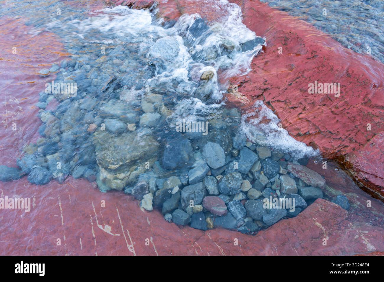 Der Fluss fließt durch rote Felsformationen und schafft natürliche Schönheiten. Waterton, ab Stockfoto