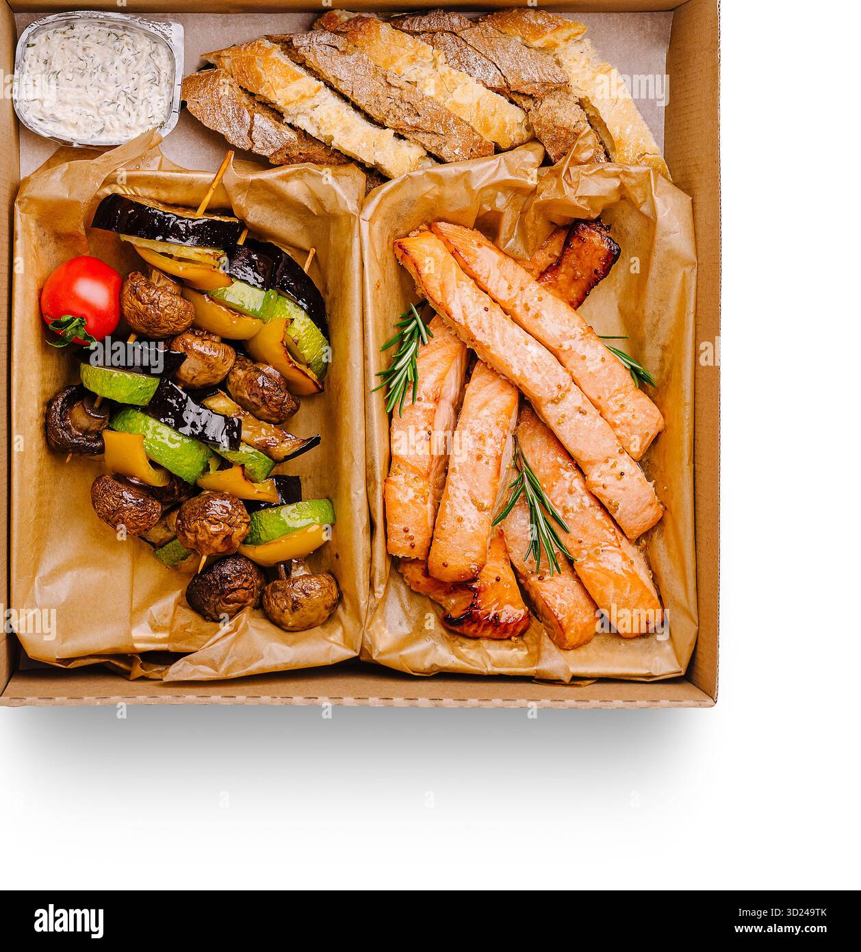 Köstlicher gegrillter Lachs und Gemüse in einer Take-Out-Box Stockfoto