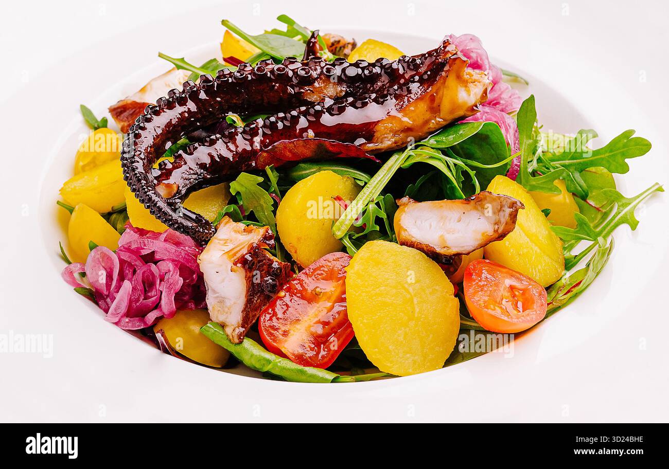 Farbenfroher Salat mit Tintenfisch, Rucola und Erbtomaten in einer Schüssel Stockfoto