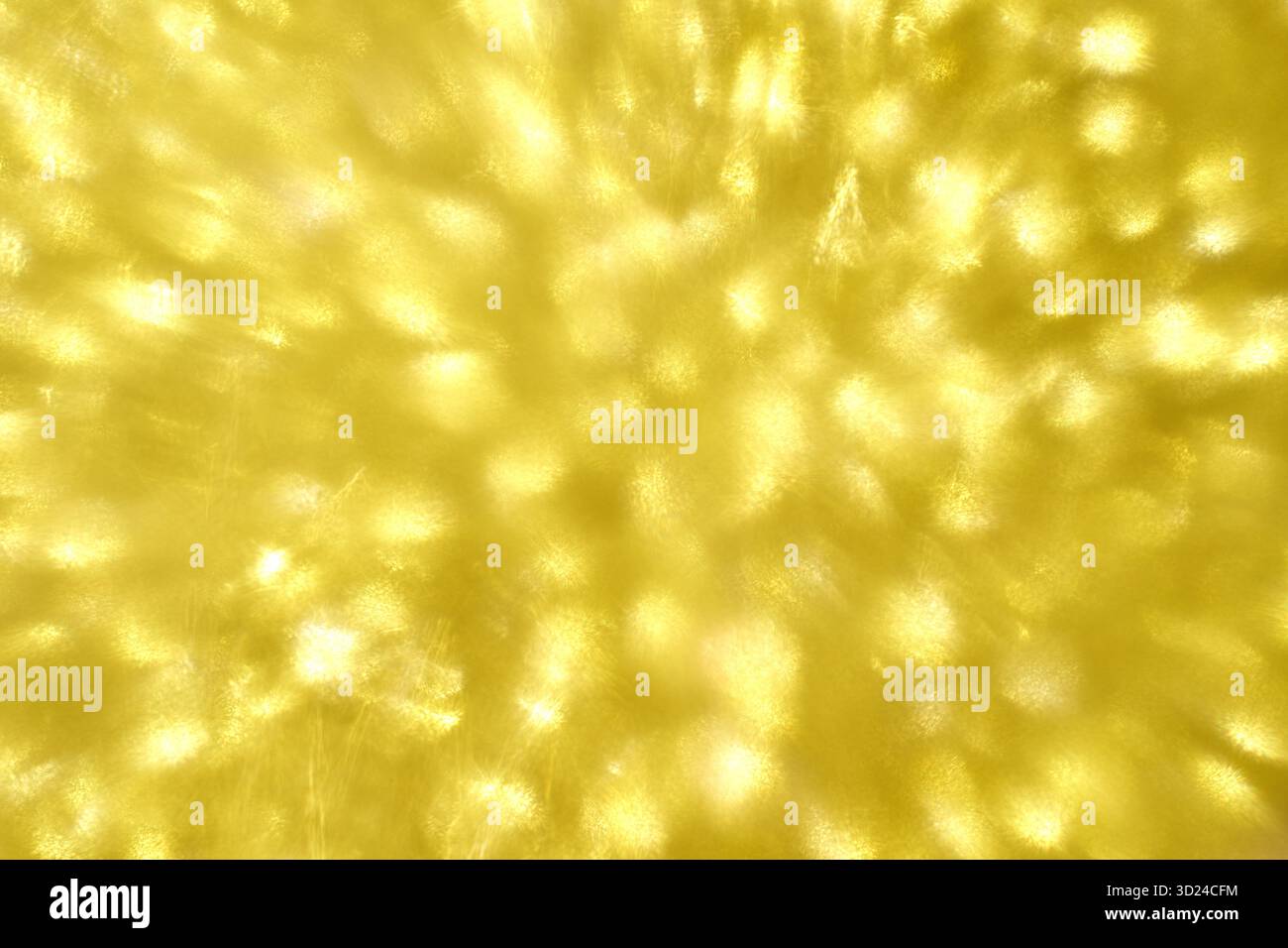 Goldenes abstraktes Licht mit funkelndem Bokeh-Muster in leuchtendem warmem Gelb Stockfoto