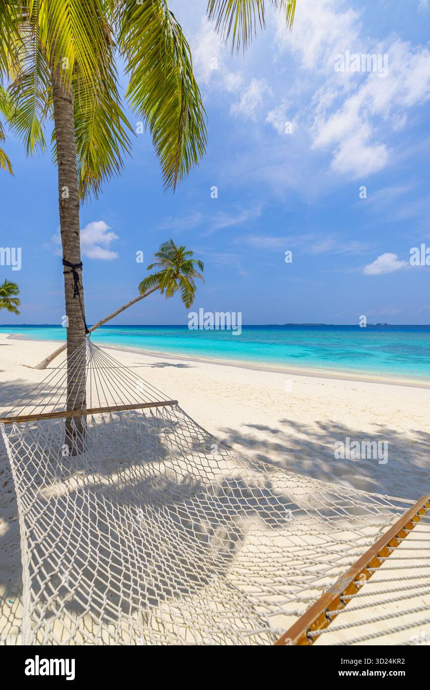Entspannende tropische Strandlandschaft mit Hängematte Schaukel unter Palmen ruhiger Meerblick sonniger weißer Sand ruhiger Sommerurlaub Reise Natur Hintergrund Stockfoto