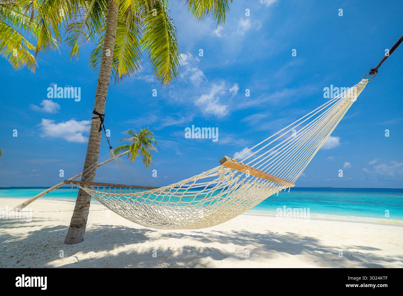 Entspannende tropische Strandlandschaft mit Hängematte Schaukel unter Palmen ruhiger Meerblick sonniger weißer Sand ruhiger Sommerurlaub Reise Natur Hintergrund Stockfoto