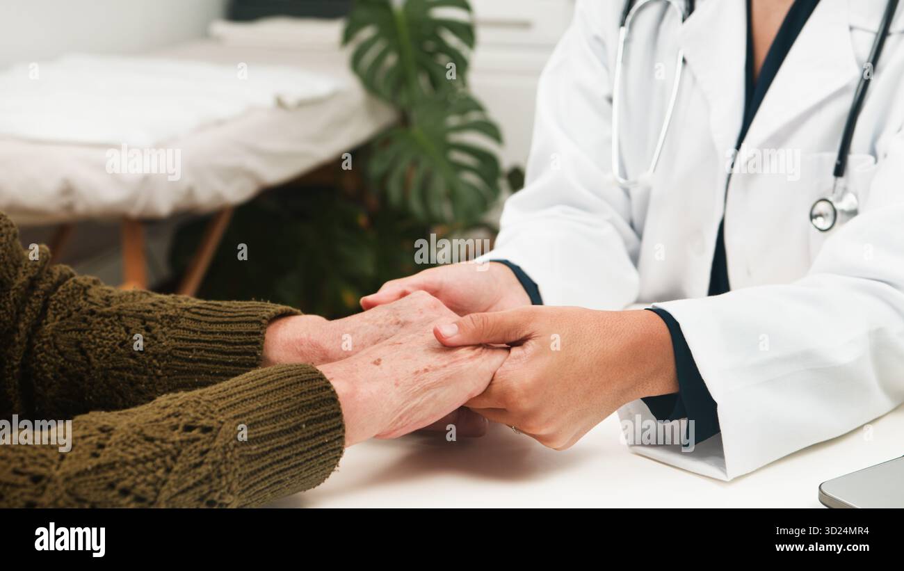 Der Pflegende Arzt Hält Die Hände Älterer Patienten In Der Klinik Für Mitfühlende Medizinische Unterstützung Stockfoto