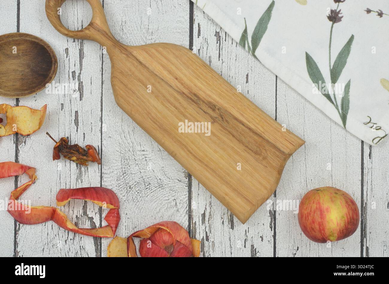 Wo man Apfelschalen und Bioabfälle wegwirft - Umwelterziehung in der Landküche. Schneidebrett, Küchentuch, Apfel, Kern. Stockfoto