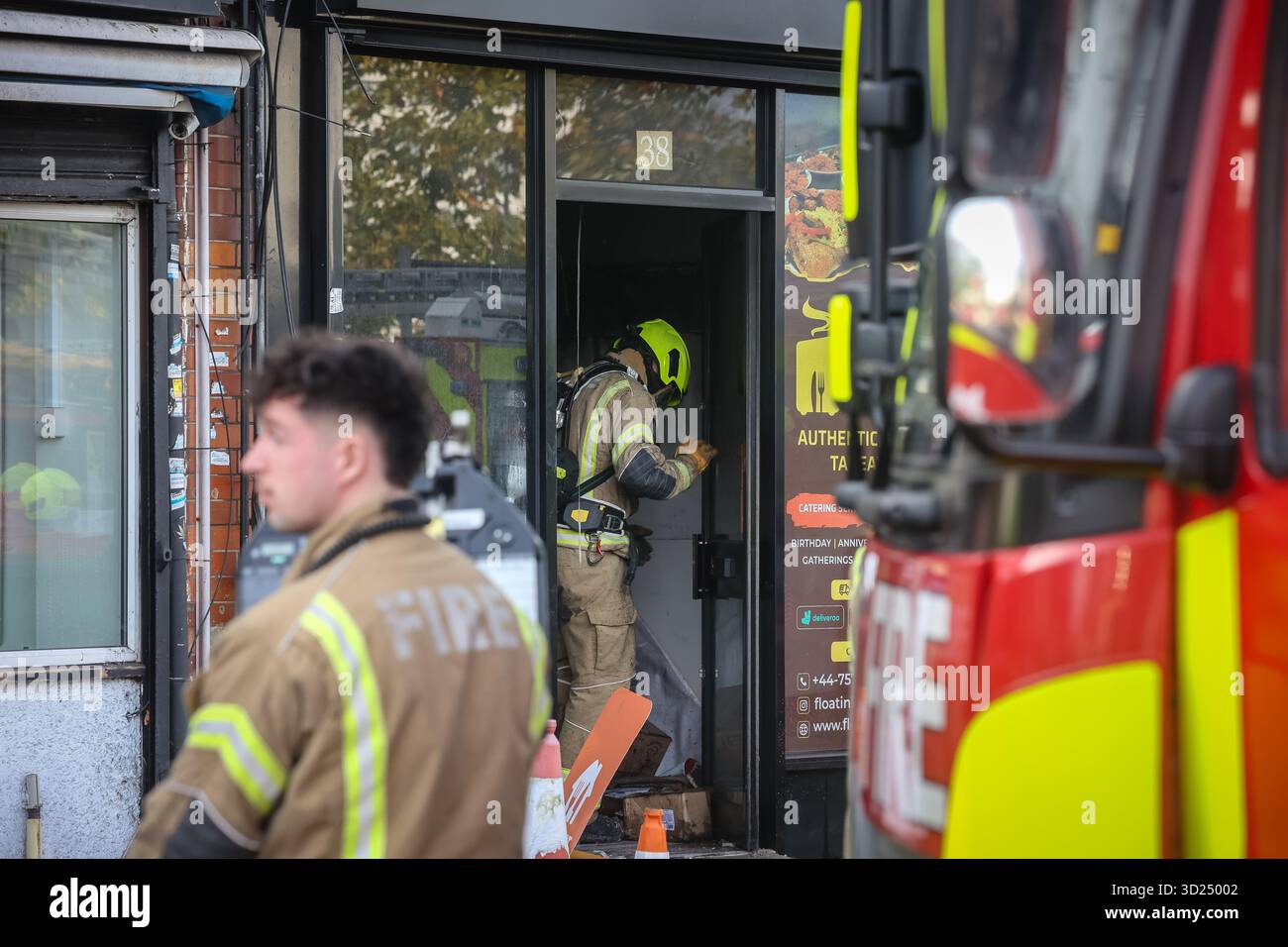 LONDON, Großbritannien - 30. Oktober 2025: Feuerwehrleute der Londoner Feuerwehr gehen in einem Fast-Food-Restaurant an der Sangley Road in Catford, South London, in Brand. Fünf Feuerwehrfahrzeuge und ein Kommandofahrzeug waren am Tatort. London Ambulance Service war ebenfalls anwesend, verließ aber kurz darauf, da keine Verletzungen gemeldet wurden. Die Brandursache ist noch nicht bekannt. Stockfoto