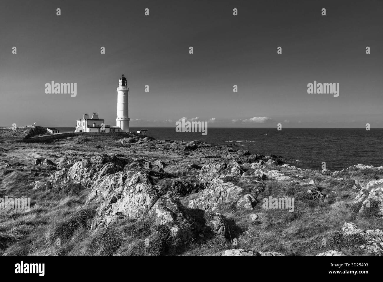 Schwarz-weiß-Blick auf den Leuchtturm von Corsewall und die zerklüfteten Küstenklippen an den Rhins of Galloway Stockfoto