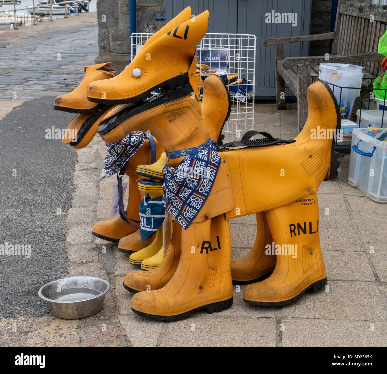 Hundefiguren aus alten gelben wellington-Stiefeln an der RNLI-Station, Lyme Regis, Dorset, UK Royal National Lifeboat Institution Stockfoto