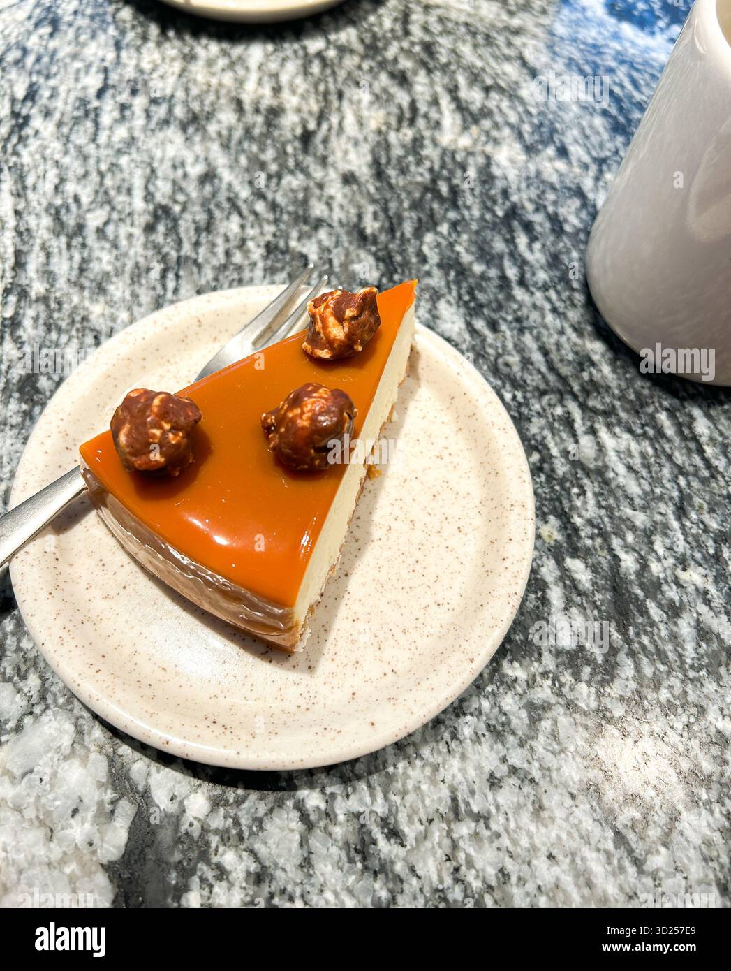 Café-Bar, Dessert-Moment mit Kuchen und Tee. Flache Käsekuchenscheibe und dampfende Tasse Tee. Bild für Food-Blogging, Café-Rezensionen und Social Media Stockfoto