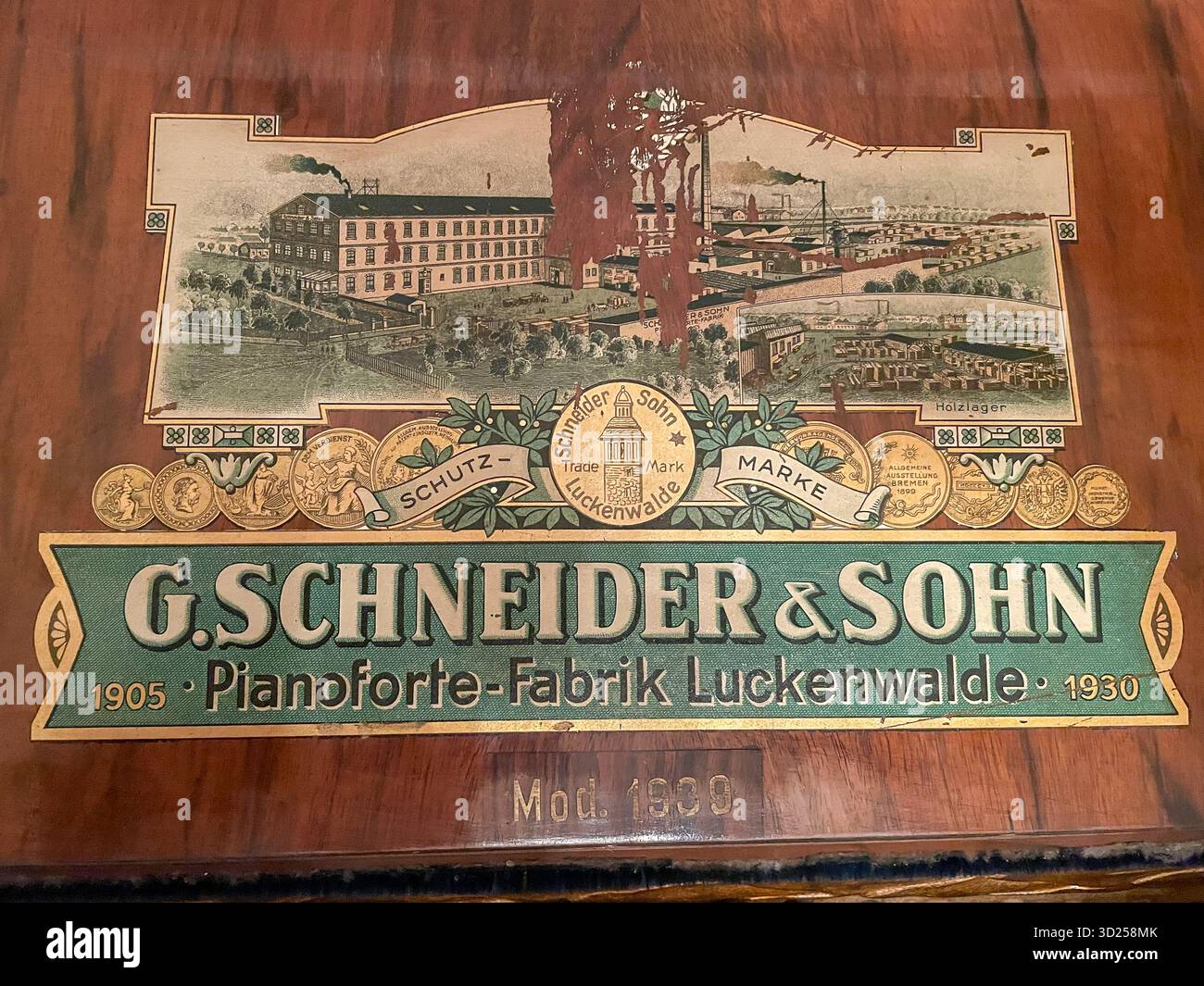 Schneider & Sohn Logo-Aufkleber auf einem antiken 1930-Klavier mit Siegermedaillen Stockfoto