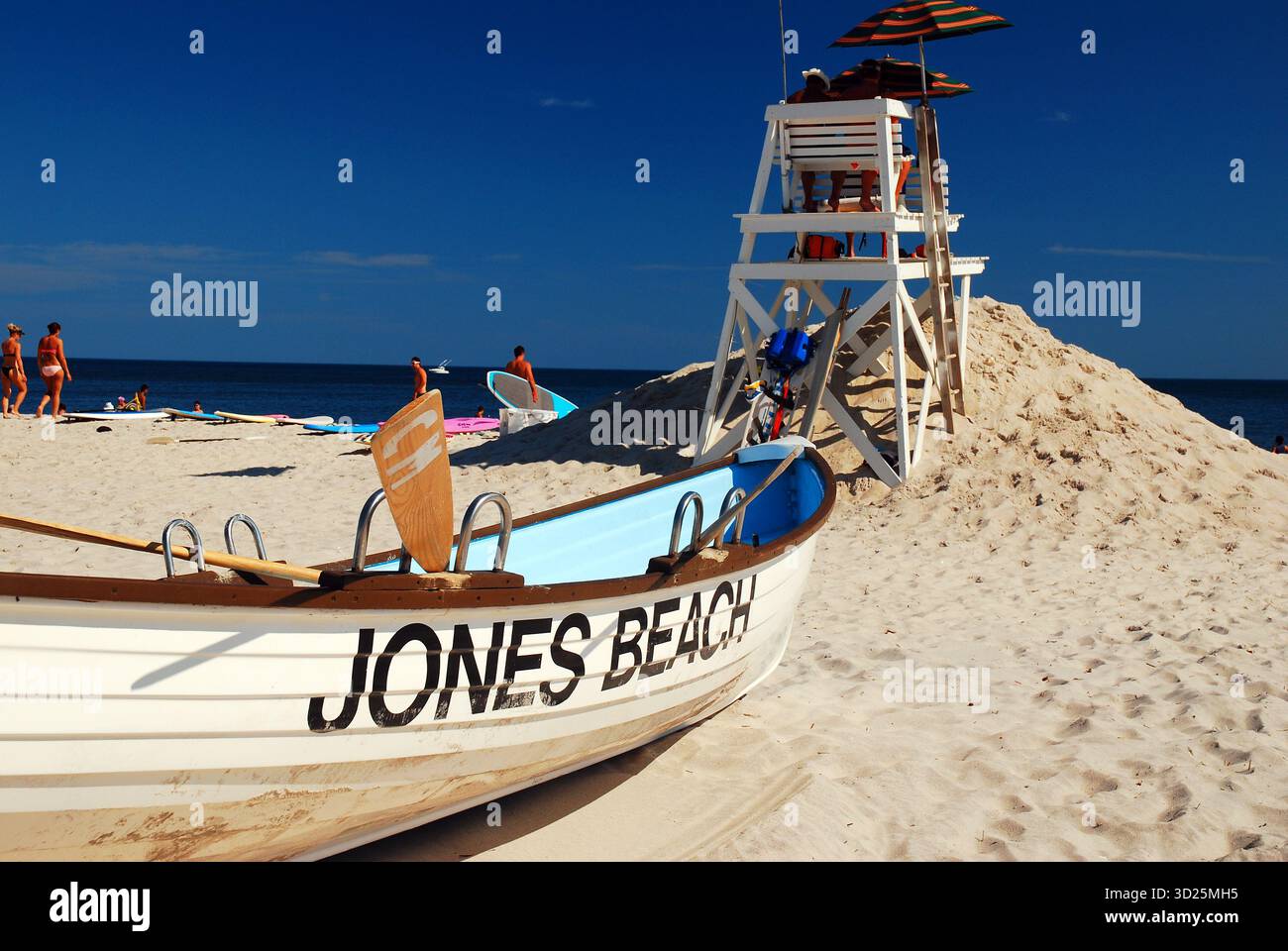 Ein Rettungsruderboot steht an einem Sommertag im Jones Beach State Park, New York, auf Long Island hinter einem Rettungsschirm Stockfoto