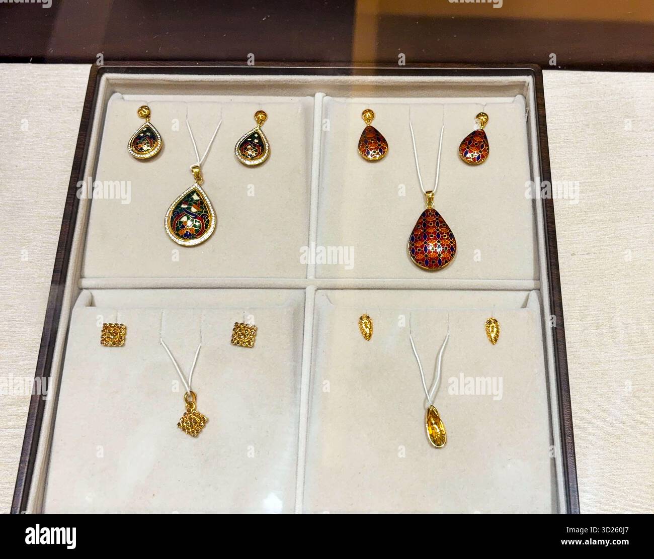 Elegante Anhänger- und Ohrringe-Sets in Tropfenform in einer Schmuckvitrine Stockfoto