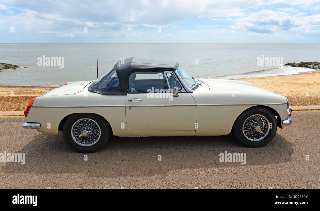 Klassischer weißer MGB Roadster parkt an der Strandpromenade, Strand und Meer im Hintergrund Stockfoto
