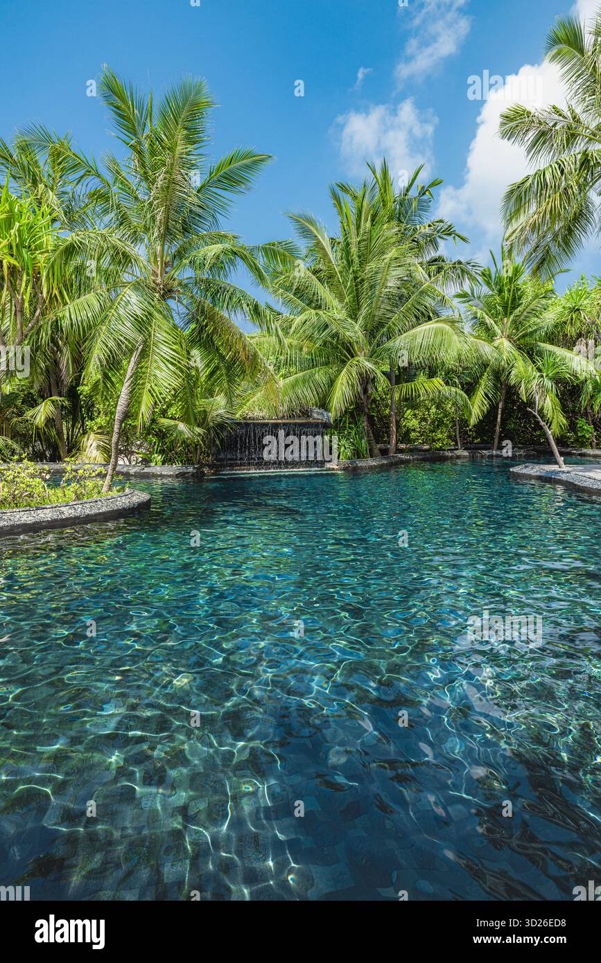 Luxuriöses tropisches Resort Pool mit Wasserfall, Palmen, exotischer Gartenlandschaft, ruhiges Urlaubsparadies Stockfoto