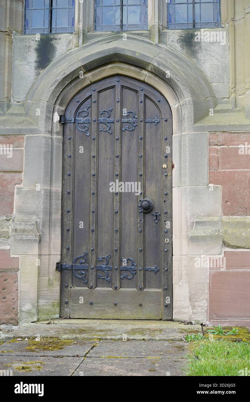 Nahansicht einer Kirchentür aus Holz und Eisen und umliegender Steinmauerwerk. Stockfoto