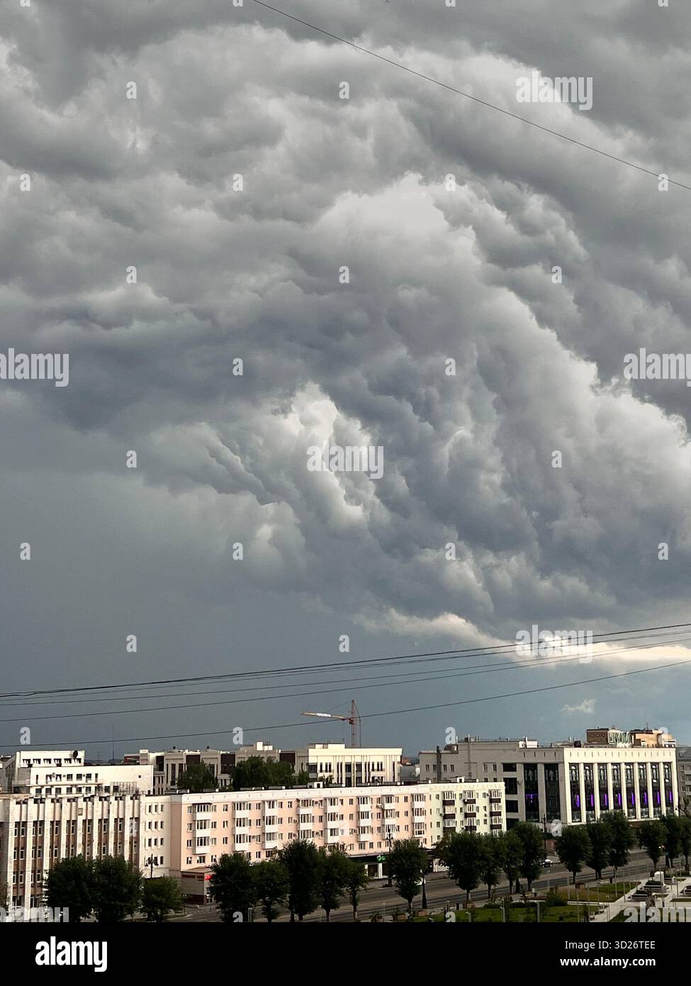 Große Wolken hangen über der Stadt mit der Gefahr eines Gewitters - Smartphone-aufgenommenes Stockfoto