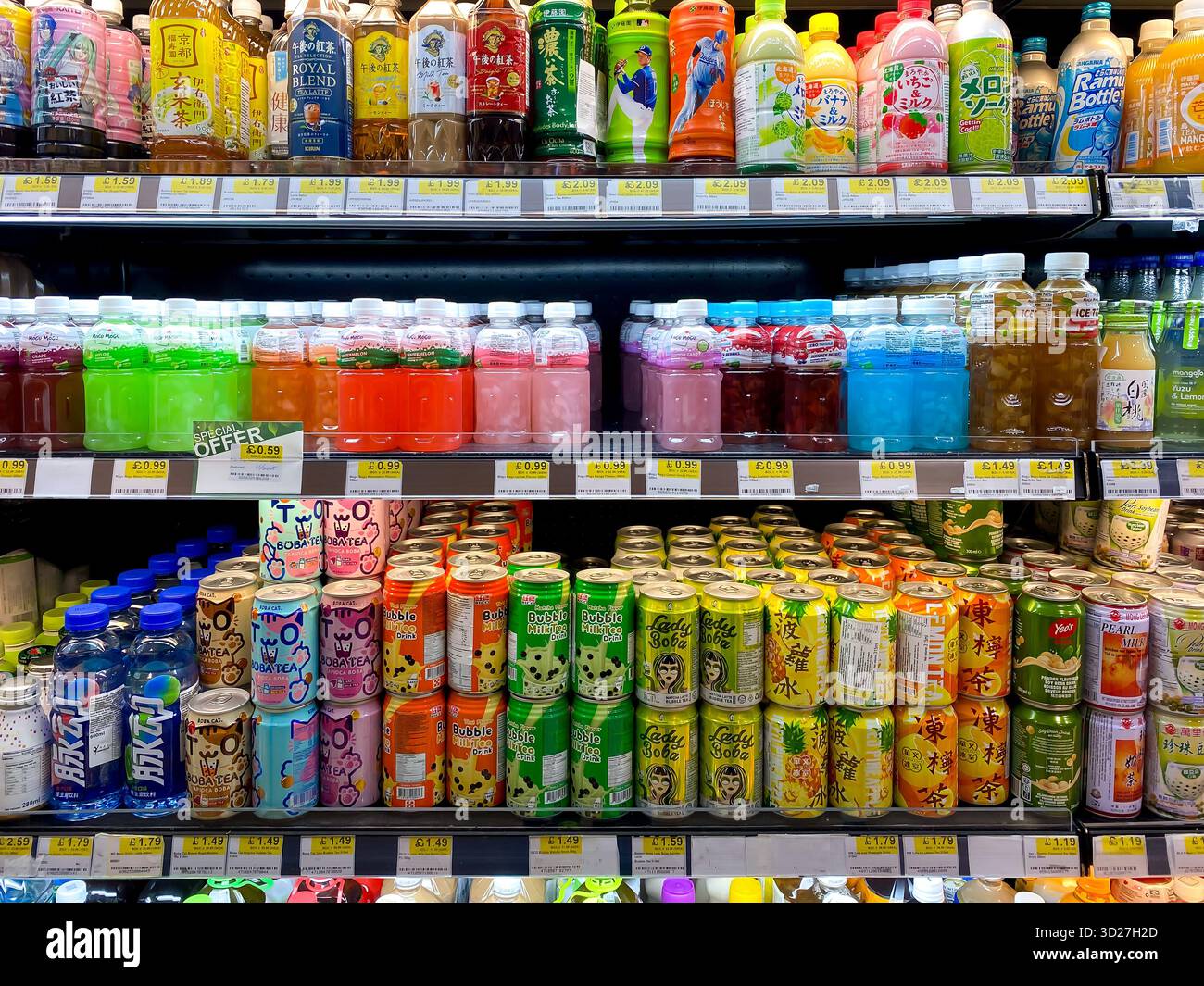 Flaschen mit Getränkedosen in bunten, verlockenden Verpackungen in Regalen in einem asiatischen Supermarkt - Smartphone-aufgenommenes Stockfoto