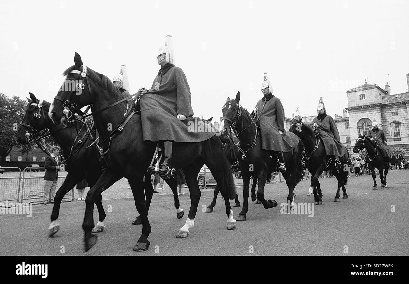 Eine herrliche Prozession findet in der Horse Guards Parade in London statt. Die berühmte Household Cavalry, die in ihren traditionellen scharlachroten Tuniken und Bärenfellmützen gekleidet ist, marschiert in perfekter Form, während sie ein großes Spektakel führen, ein zeitloses Schauspiel britischer Herkunft und militärischer Präzision. Stockfoto
