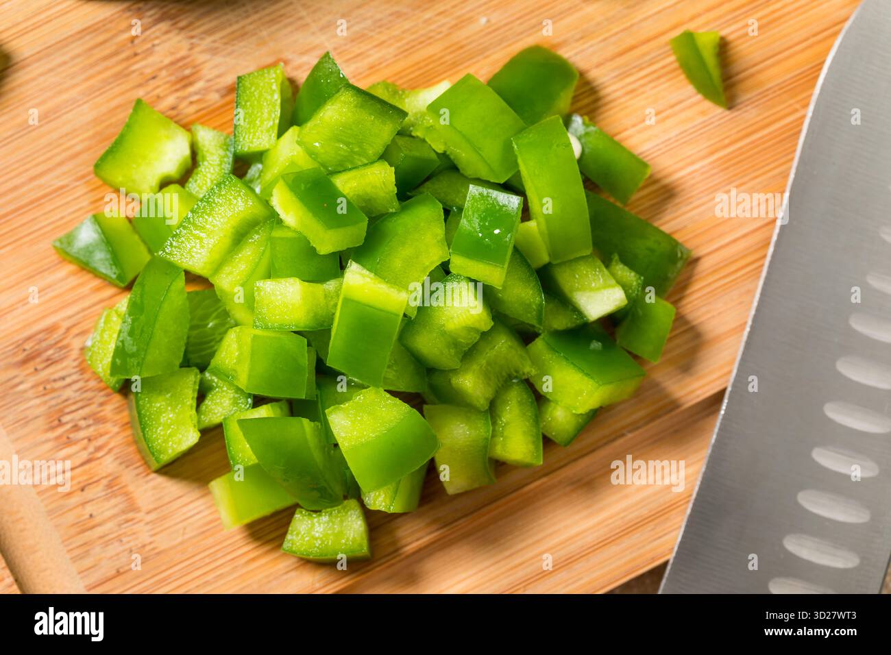 Bio gewürfelte grüne Paprika auf einem Schneidebrett Stockfoto