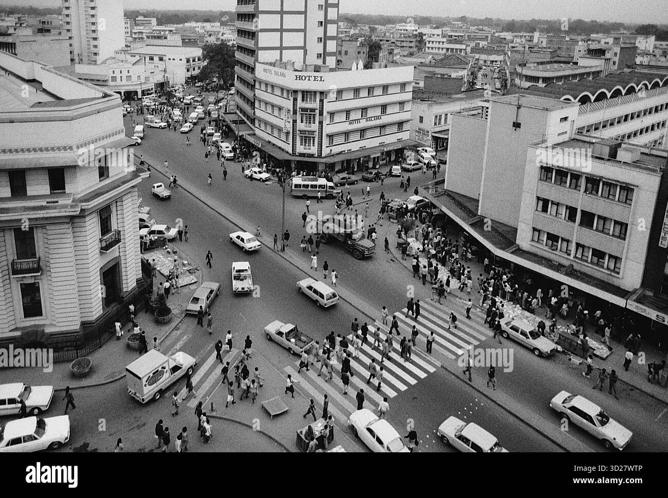 Nairobi's Central Business District – Eine geschäftige Szene fängt das Herz der kenianischen Hauptstadt ein. Diese legendäre Straßenlandschaft in Nairobi zeigt die lebendige Energie der Stadt, während der Verkehr durch die Kreuzung von Kenyatta Avenue und Ronald Ngala Street fließt. Das Foto bietet neben modernen Fahrzeugen einen Einblick in die historische Architektur der Stadt und spiegelt Nairobis dynamisches Wachstum und Evolution wider. Stockfoto