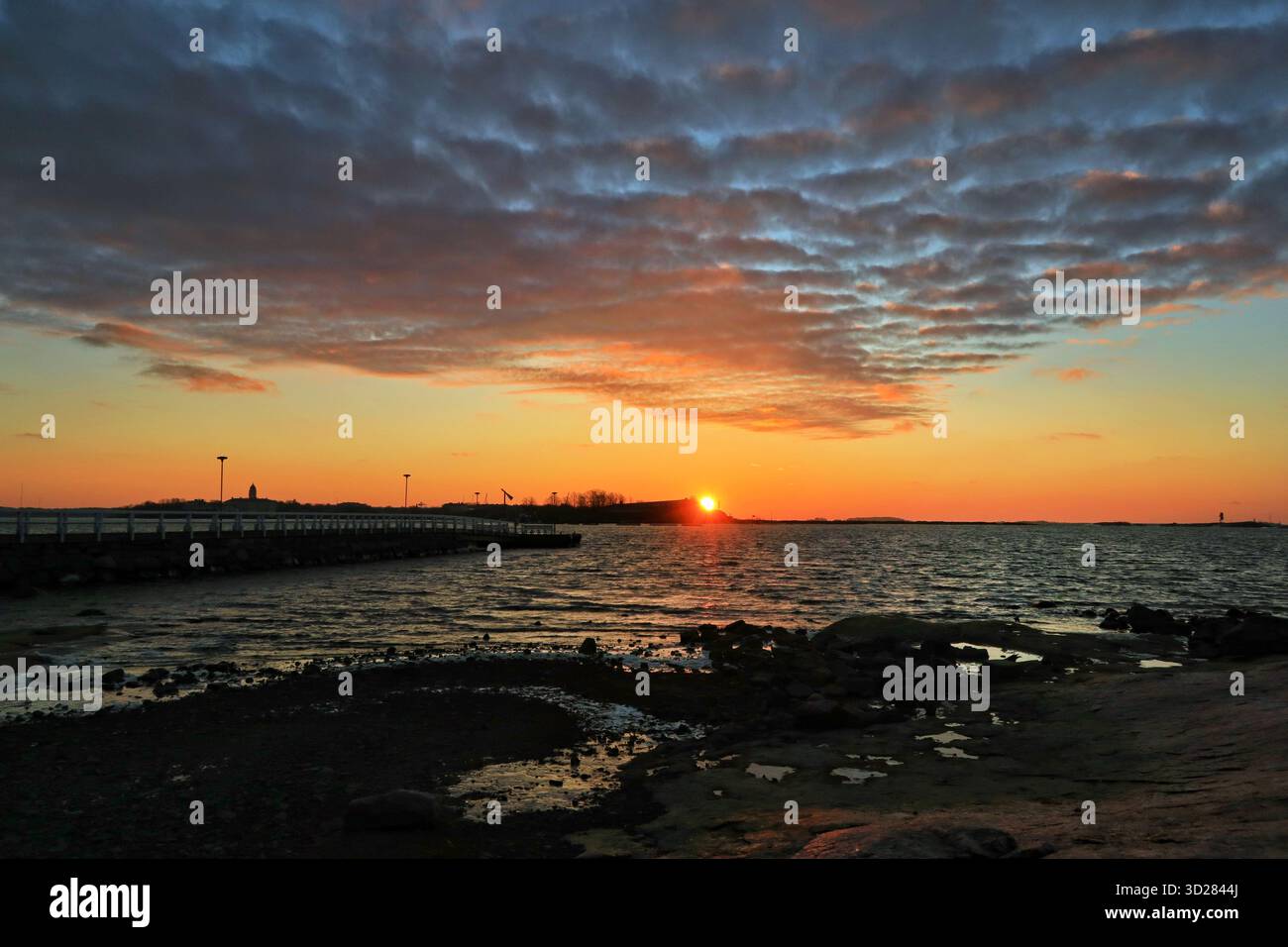 Sonnenaufgang an einem schönen, aber kalten Morgen im Dezember. Die Sonne geht hinter der Festungsinsel Särkkä bei Suomenlinna in Finnland auf. Ich wollte es Stockfoto