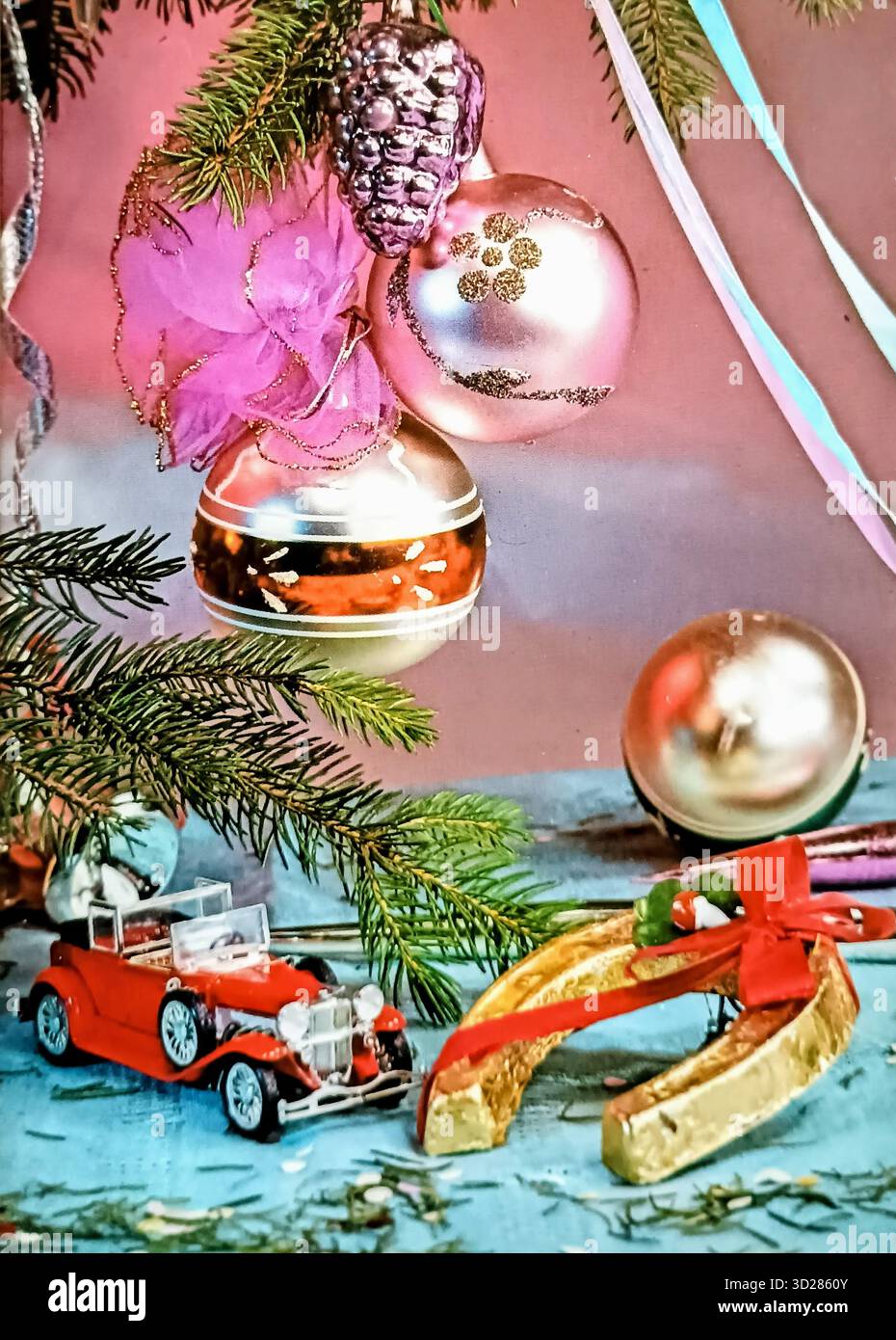 Jugoslawien, 1970er: Eine lebendige Vintage-Grußkarte zu Neujahr und Weihnachten mit einer festlichen Collage aus einer verzierten Kiefer, einem Modellauto, einem Hufeisen und bunten Pailletten. Ein authentisches Archivbeispiel für Urlaubsästhetik und Grafik in der Sozialistischen Bundesrepublik Jugoslawien (SFRJ). Stockfoto