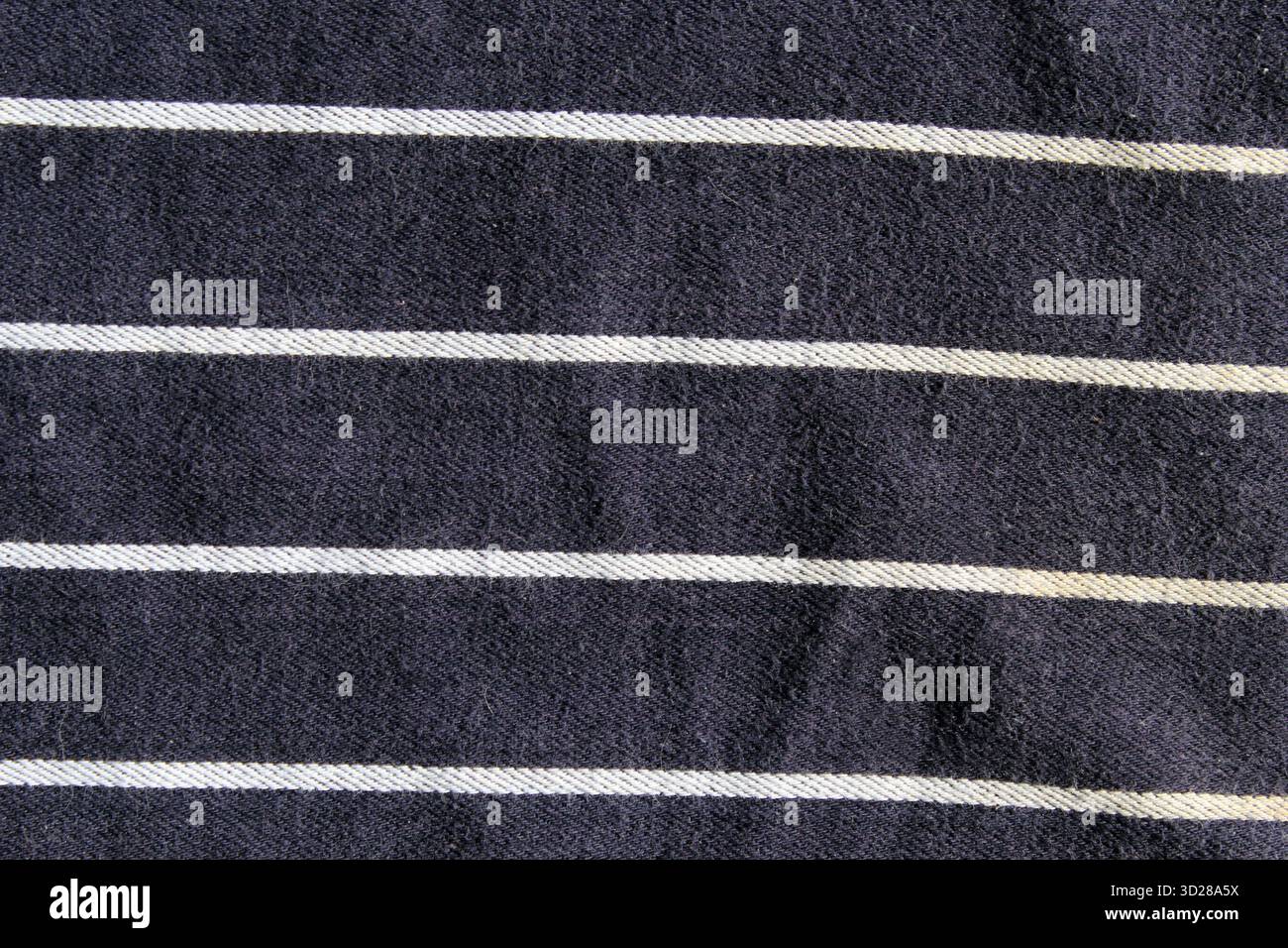 Nahaufnahme aus marineblauem Stoff mit horizontalen weißen Streifen und abstraktem texturiertem Hintergrund Stockfoto