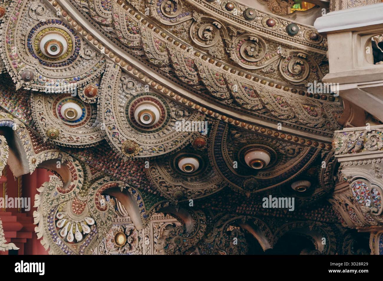 Dekorative architektonische Schnitzerei mit kreisförmigen Motiven im Drachenstil und mehrschichtigen Texturen aus dem Innenraum des Erawan Museums. Stockfoto