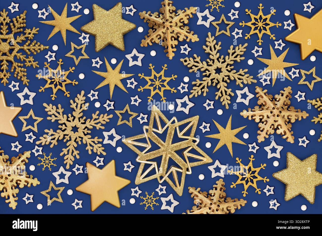 Weihnachtsdekorationen goldener Stern, Schneeflocke, symbolischer weißer Schneeflocken Hintergrund auf blau. Festliches Design für die Weihnachtszeit. Grußkarte. Stockfoto